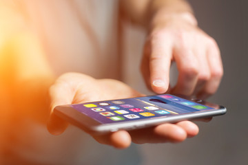 Hand holding black smartphone with operating system screen