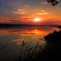 Obraz premium warm misty morning at the river. majestic sunset. colorful clouds reflected in the water.