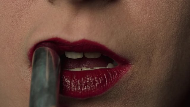 Close up, Woman Paints Her Lips With Lipstick On A Black Background