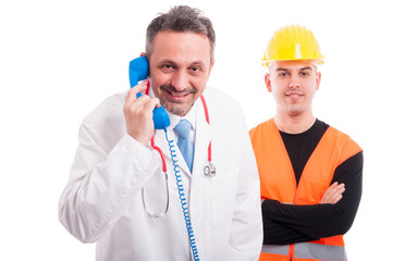 Medic holding telephone receiver with constructor aside smiling