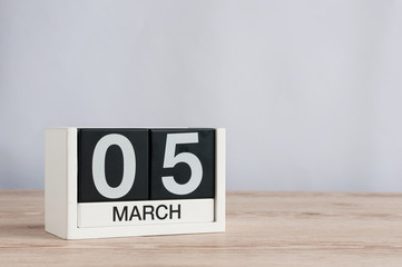 March 5th. Day 5 of month, wooden calendar on light background. Spring time, empty space for text