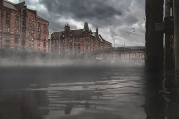 low angle view over water of old warehouse district Speicherstadt in Hamburg, Germany on gloomy day