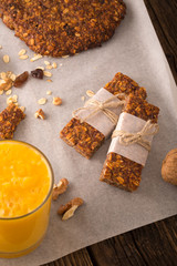 Cereal bars with raisins, nuts and orange juice.