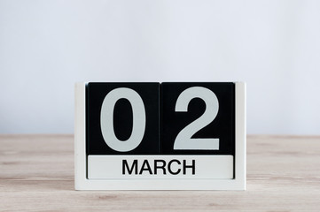 March 2nd. Day 2 of month, everyday calendar on wooden table background. Spring time, empty space for text