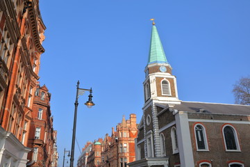 LONDON, UK: Grosvenor Chapel and red brick Victorian houses facades in S Audley Street (borough of Westminster)