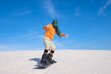 Man snowboarding amongst the sand dunes - unusual use