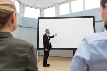 Businessmann zeigt auf weiße Leinwand, Meeting und Seminar