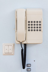 altes analoges Telefon mit Telefonschnur, Aufhängung an Wand