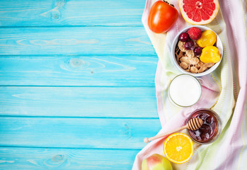 Bowl of healthy corn flakes breakfast cereal, milk and fruits on blue wood table © voloshin311