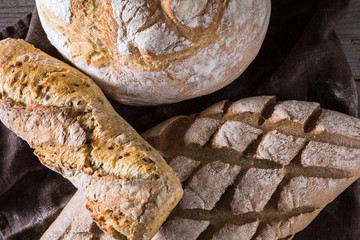 Several types of fresh bread lying on an old wooden table