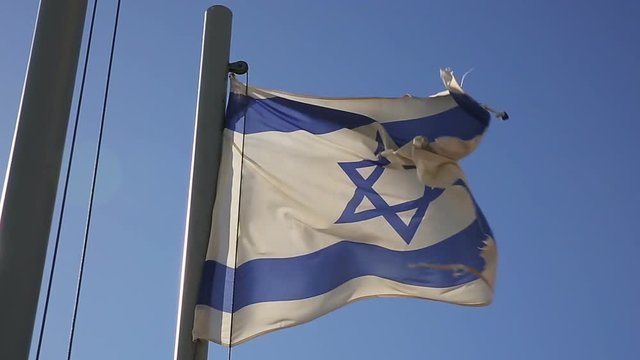 Flags of Israel flapping on mast in a strong wind