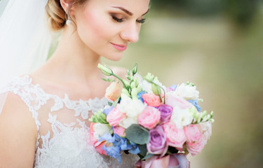 Bride clothes her eyes while she holds tender wedding bouquet