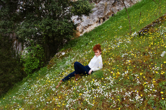 Retrato de una preciosa mujer joven y pelirroja en un campo de flores 