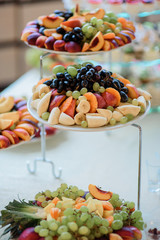 Sliced fruits, bananas, grapes served on large dishes