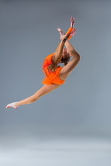 Young beautiful girl doing gymnastick jump