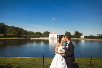 wedding couple kissing  in the park by the lake