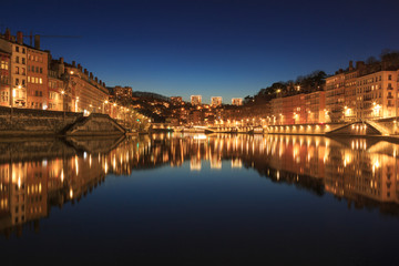 Fototapeta na wymiar Illuminated Vieux Lyon reflected in the Saone river during a tranquil evening in Lyomn, France.