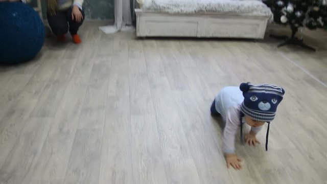 baby boy crawling for ball of yarn