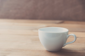 white cup on wooden wall background