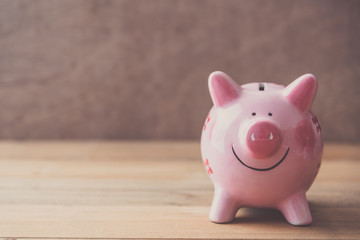 pink piggy bank on wooden table background