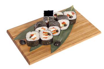 Sushi rolls on wooden Board with leaves of leeks and black sign for logo and name