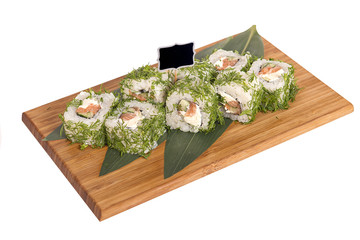 Sushi rolls on wooden Board with leaves of leeks and black sign for logo and name