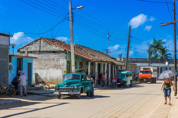 Straßenszene in Santa Clara Kuba mit einem parkendem blauen Oldtimer - Serie Kuba Reportage