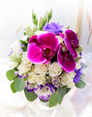 Gorgeous wedding bouquet made of violet orchids and roses
