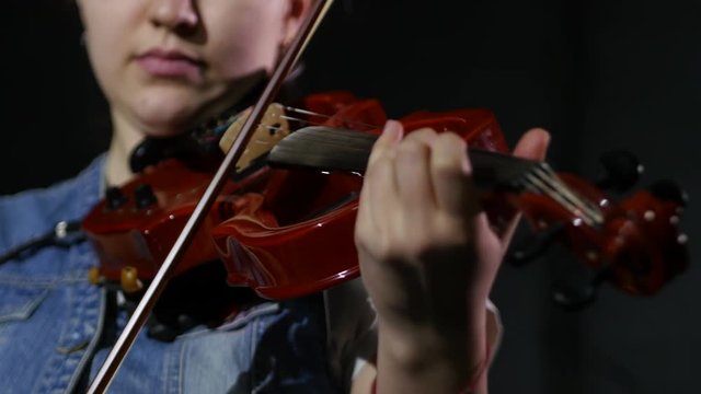 4k girl playing the violin with her eyes closed, studio, black background, close-up