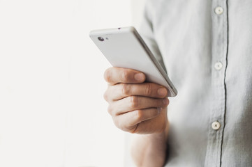 Using smart phone. Male hand holding mobile phone