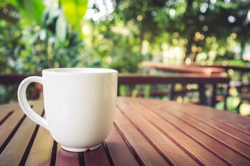 Cup of coffee on wooden table in coffee shop.