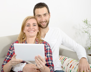 happy young couple using digital tablet