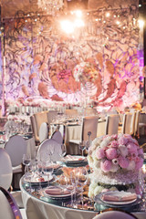 Round bouquet stands in the centre of rich served dinner table