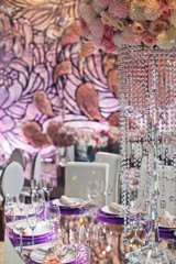 Long crystal chains hang from colorful bouquet over dinner table