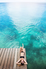 Fototapeta premium Gorgeous woman in bikini sunbathing at seaside enjoying pleasant sunlight. Summer concept. Enjoying peaceful beach.