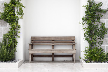 Wooden bench in front of concrete wall with ivy