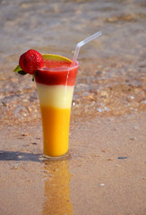 Cocktail in a glass with strawberries, mango, guava on the seafront