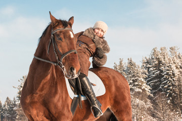 Obraz premium Woman in brown dress and brown horse in a winter