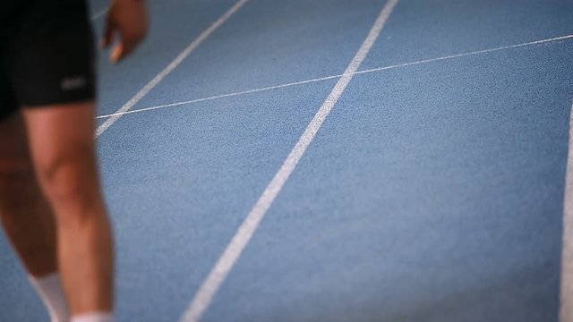 Man with leg prosthetics running on the track and field sprint court