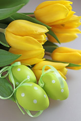 Bouquet of fresh yellow tulips with easter eggs