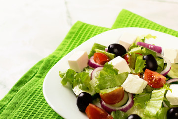 Fresh greek salad on white table