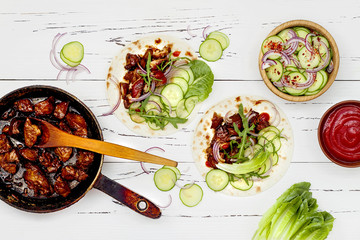 Korean slow cooked beef tacos with asian cucumber slaw and sriracha ketchup. Top view, flat lay,...