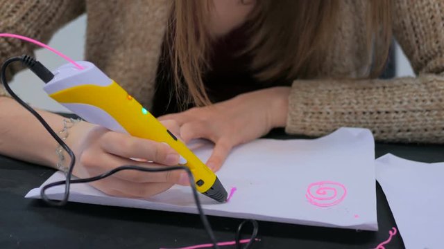 Close up shot. Woman using 3D printing pen. Exhibition of modern technologies. Future and technology concept