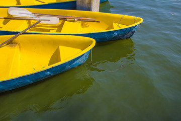 Fototapeta na wymiar Yellow rowboat on water in lake