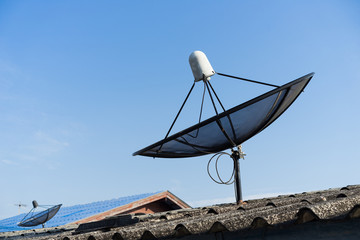 Satellite dishe on roof top, with blue sky