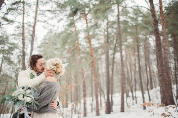 Obraz premium Beautiful romantic couple kissing in the winter park