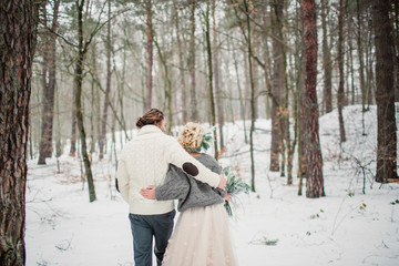 Beautiful romantic couple hugging in the winter forest