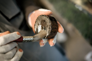 Carpenter using wood finish paint for his job in carpentry workshop