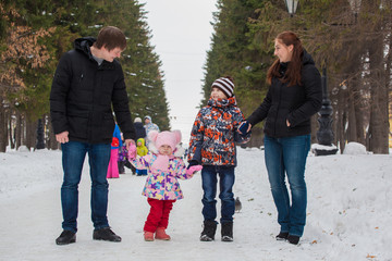 mom, dad, son and daughter on a winter walk in the park