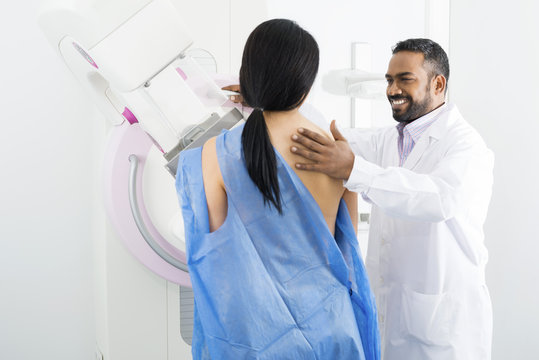 Doctor Assisting Mature Woman Undergoing Mammogram Test